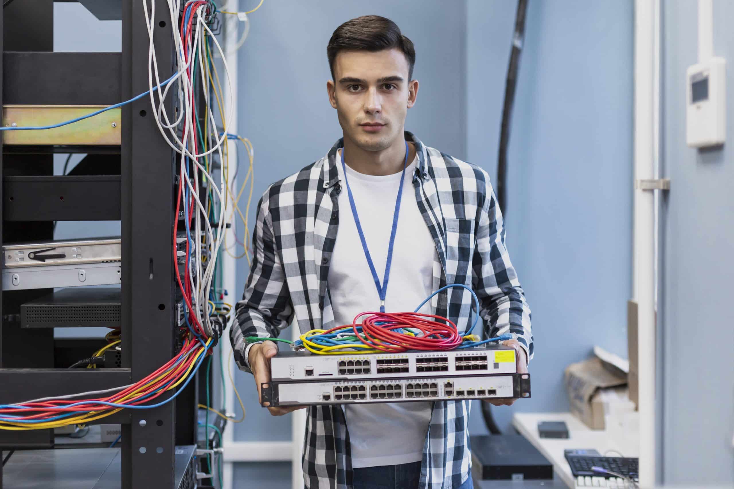 young-man-holding-ethernet-switches-wires
